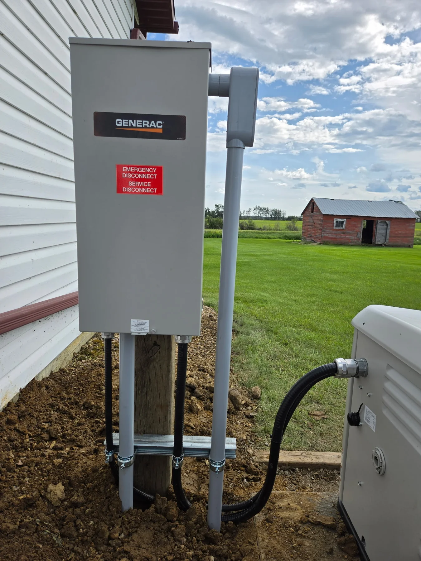 Transfer equipment and conduit installed beside a standby generator
