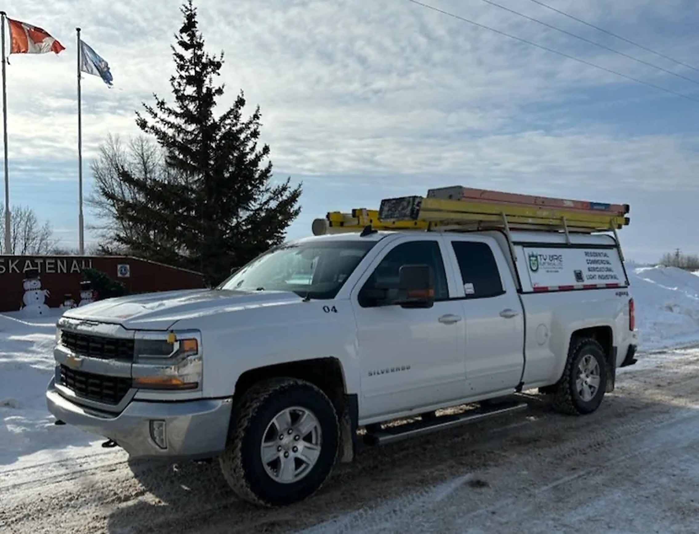Ty-Wire truck beside the Waskatenau welcome sign